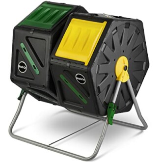 Dual-chamber compost tumbler with black, green, and yellow design on a metal stand.