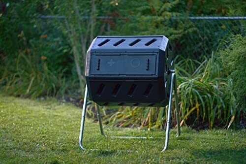 A black garden composter tumbler on a metal stand in a grassy yard.